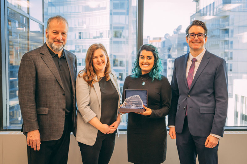 A photo of John Glowacki, Jennie Fong, Sheena Prasad and Jeff Slater holding the award