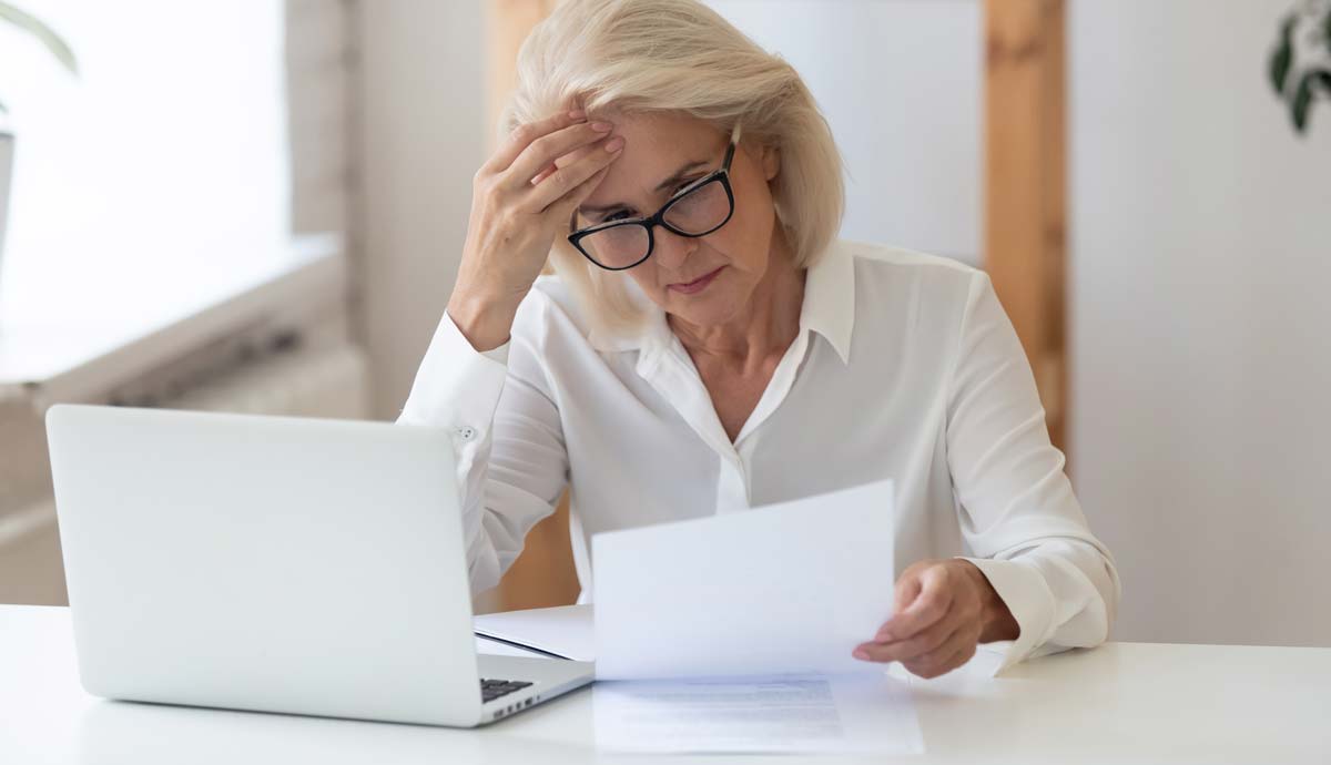 Photo: A businesswoman looks concerned looking at a cease and desist letter