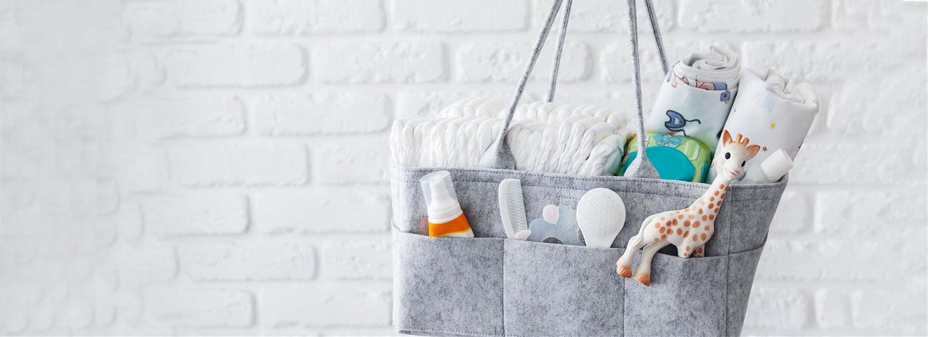bag with toy, diapers and accessories on white background
